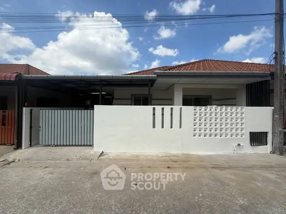 Charming single-story home with modern facade and spacious driveway under a clear blue sky.