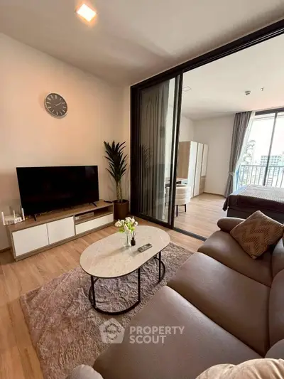 Modern living room with cozy seating and balcony view in stylish apartment