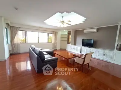 Spacious living room with elegant hardwood floors and modern furnishings in a luxury apartment.