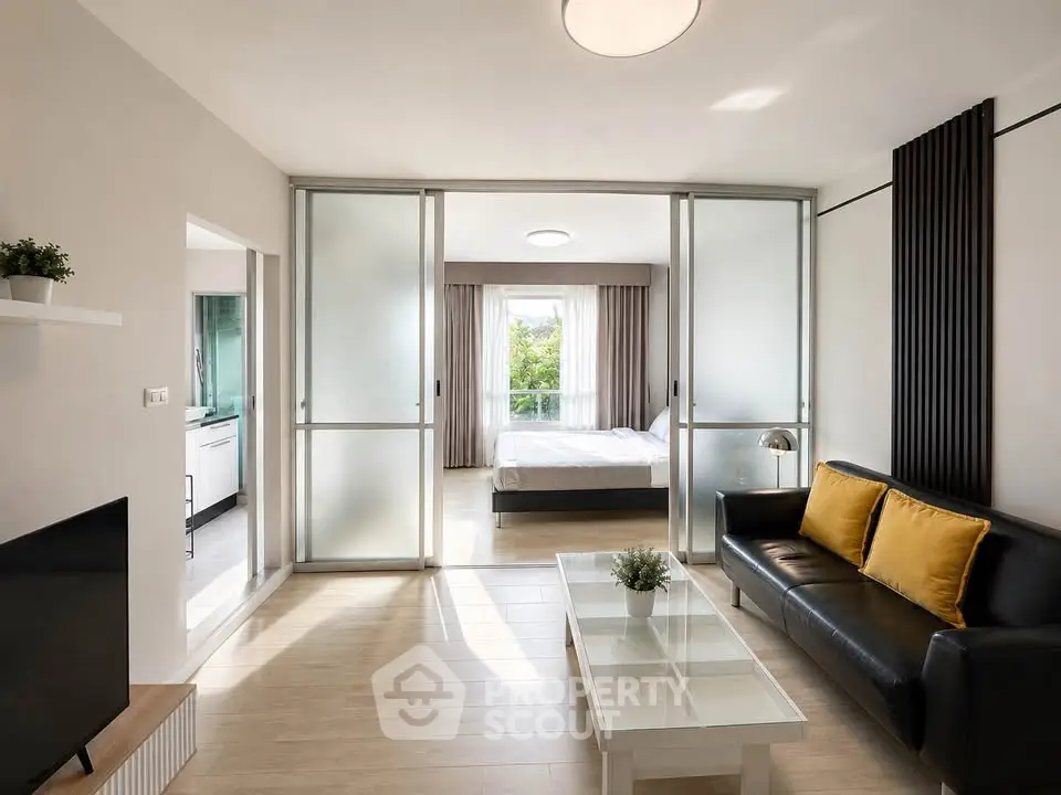 Modern living room with sliding doors leading to a bright bedroom, featuring sleek furniture and natural light.