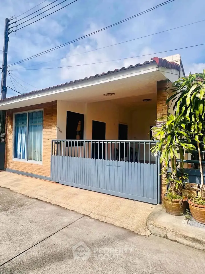 Charming single-story home with covered porch and large windows, perfect for cozy living.