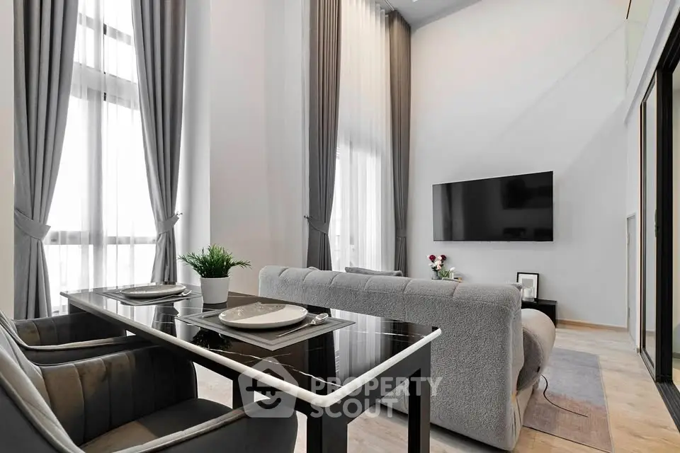 Modern living room with high ceilings, large windows, and sleek furniture for a luxurious ambiance.