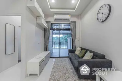 Modern living room with balcony view, featuring sleek furniture and air conditioning.