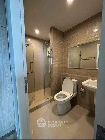 Modern bathroom with glass shower and sleek fixtures in a contemporary apartment.