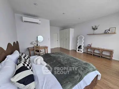 Spacious modern bedroom with stylish decor and wooden flooring