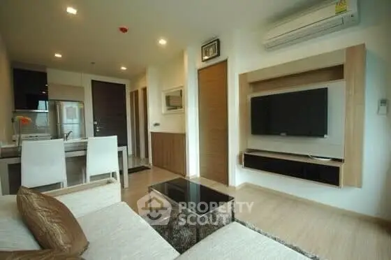 Modern living room with sleek furniture and wall-mounted TV in a stylish apartment.