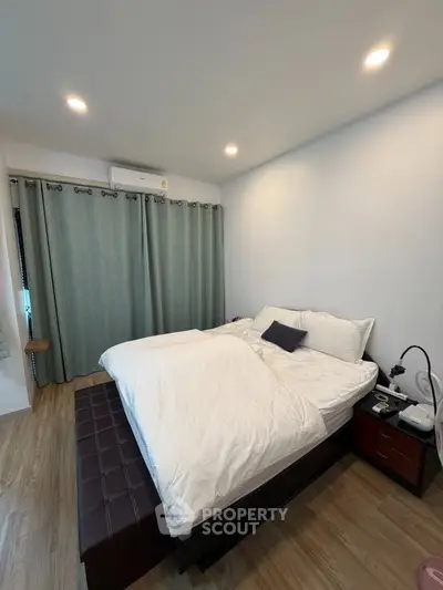 Cozy bedroom with modern decor and natural light, featuring a comfortable bed and stylish curtains.