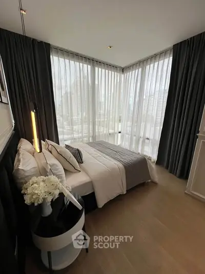 Luxurious corner bedroom with floor-to-ceiling windows and elegant decor.