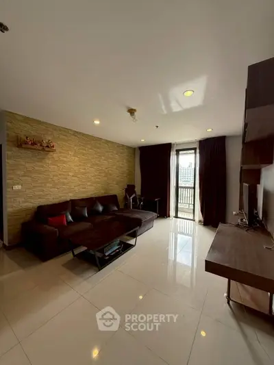 Spacious living room with modern decor and balcony view in a high-rise apartment.