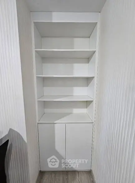 Modern built-in white storage shelves with cabinets in a minimalist interior design.