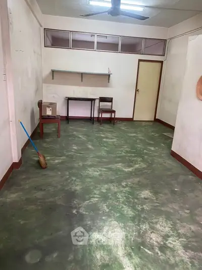 Spacious room with unique flooring and minimalist furnishings, ideal for creative renovation.