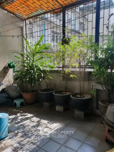 Charming balcony with lush potted plants and natural light, perfect for relaxation.
