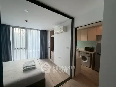 Modern studio apartment with bedroom and kitchen, featuring air conditioning and washing machine.