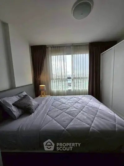 Cozy bedroom with large window and modern decor in a stylish apartment.