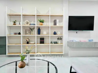 Modern living room with stylish shelving and wall-mounted TV, perfect for contemporary urban living.