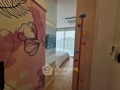 Stylish bedroom with floral wall art and colorful coat rack, featuring large windows and elegant flooring.