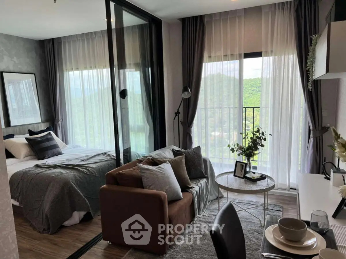 Modern studio apartment with cozy living area and scenic balcony view