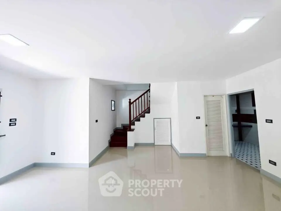 Spacious modern interior with glossy floors and elegant staircase, ideal for contemporary living.
