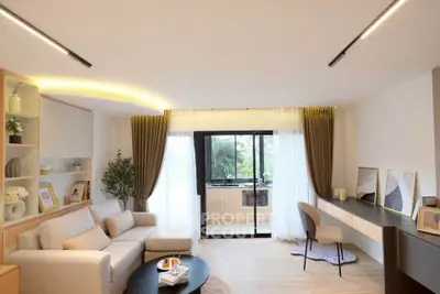 Spacious modern living room with elegant decor and large windows offering natural light.