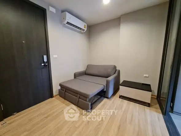 Modern living room with sofa bed and air conditioning in a cozy apartment.
