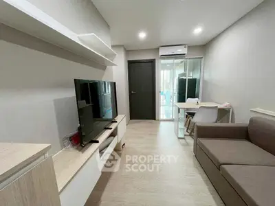 Modern living room with sleek furniture and large TV, perfect for relaxation and entertainment.