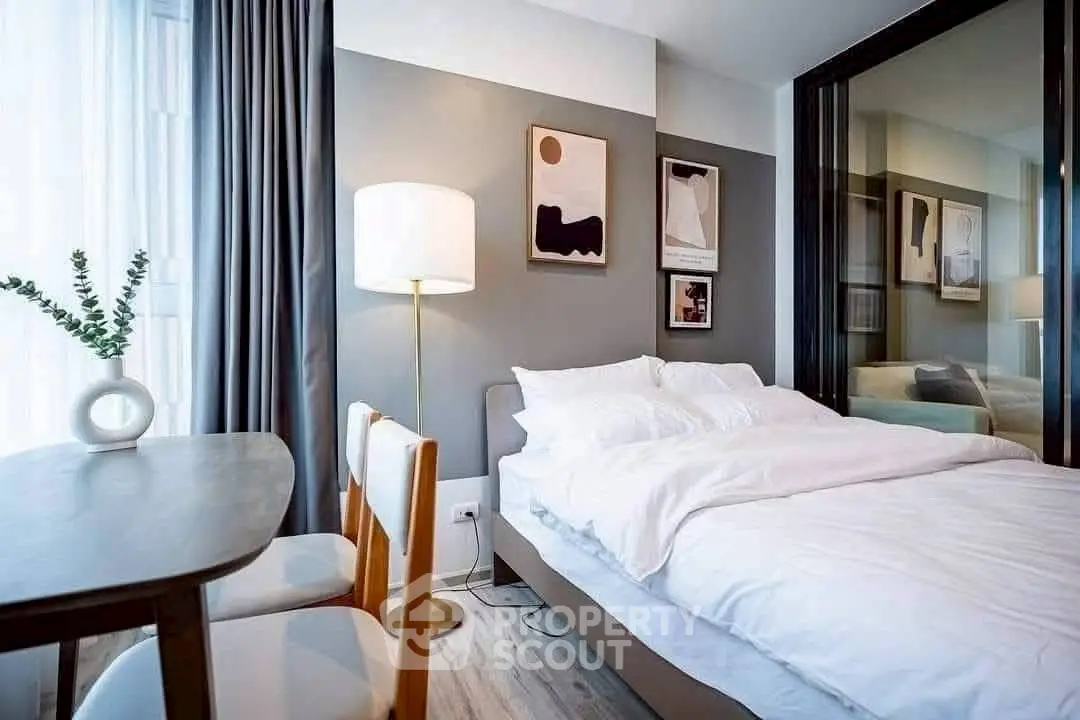 Modern bedroom with stylish decor and cozy ambiance, featuring elegant artwork and soft lighting.