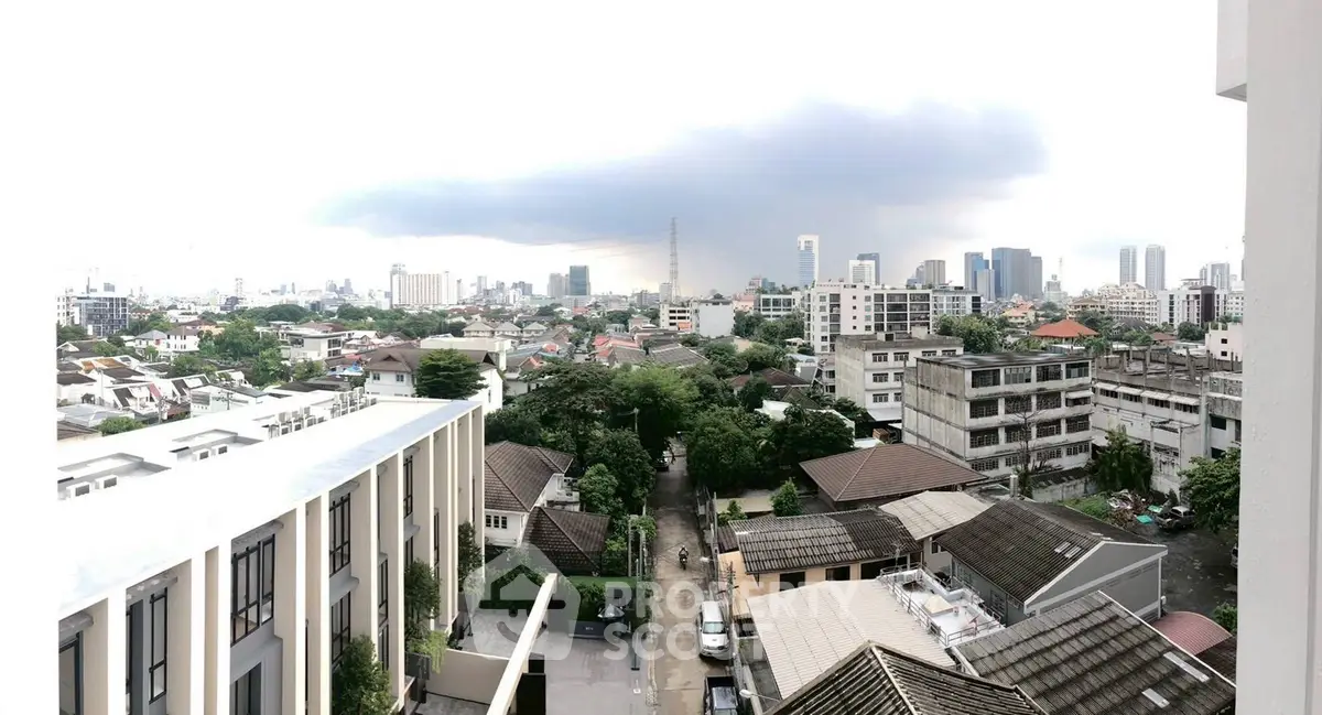 Panoramic cityscape view from a high-rise building showcasing urban residential area and skyline.
