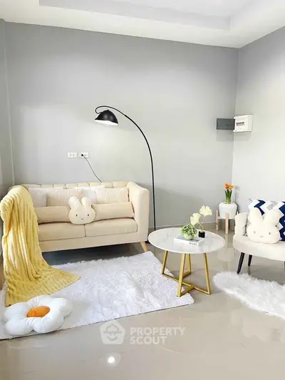 Charming living room with cozy decor, plush seating, and modern lighting, perfect for relaxation and style.