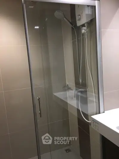 Modern bathroom with sleek glass shower enclosure and contemporary fixtures.