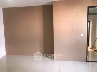 Spacious empty room with tiled flooring and neutral wall colors, perfect for customization.