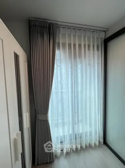 Bright bedroom corner with elegant curtains and wardrobe