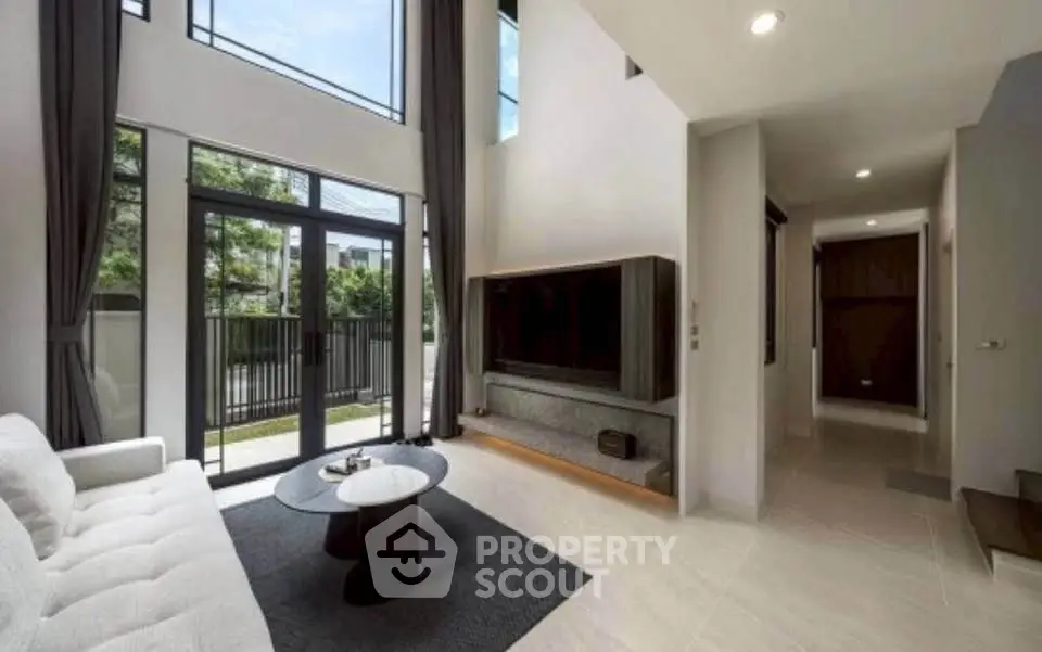 Spacious modern living room with high ceilings and large windows for natural light.