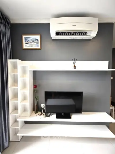 Modern living room with sleek white shelving and air conditioning unit, perfect for stylish urban living.