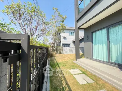 Modern residential building with private garden and patio area, showcasing contemporary architecture and outdoor space.