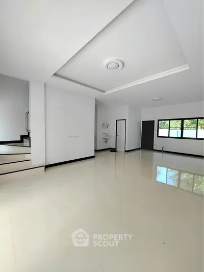 Spacious modern living room with sleek white tiles and large windows
