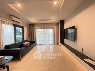 Spacious modern living room with sleek design and large windows.