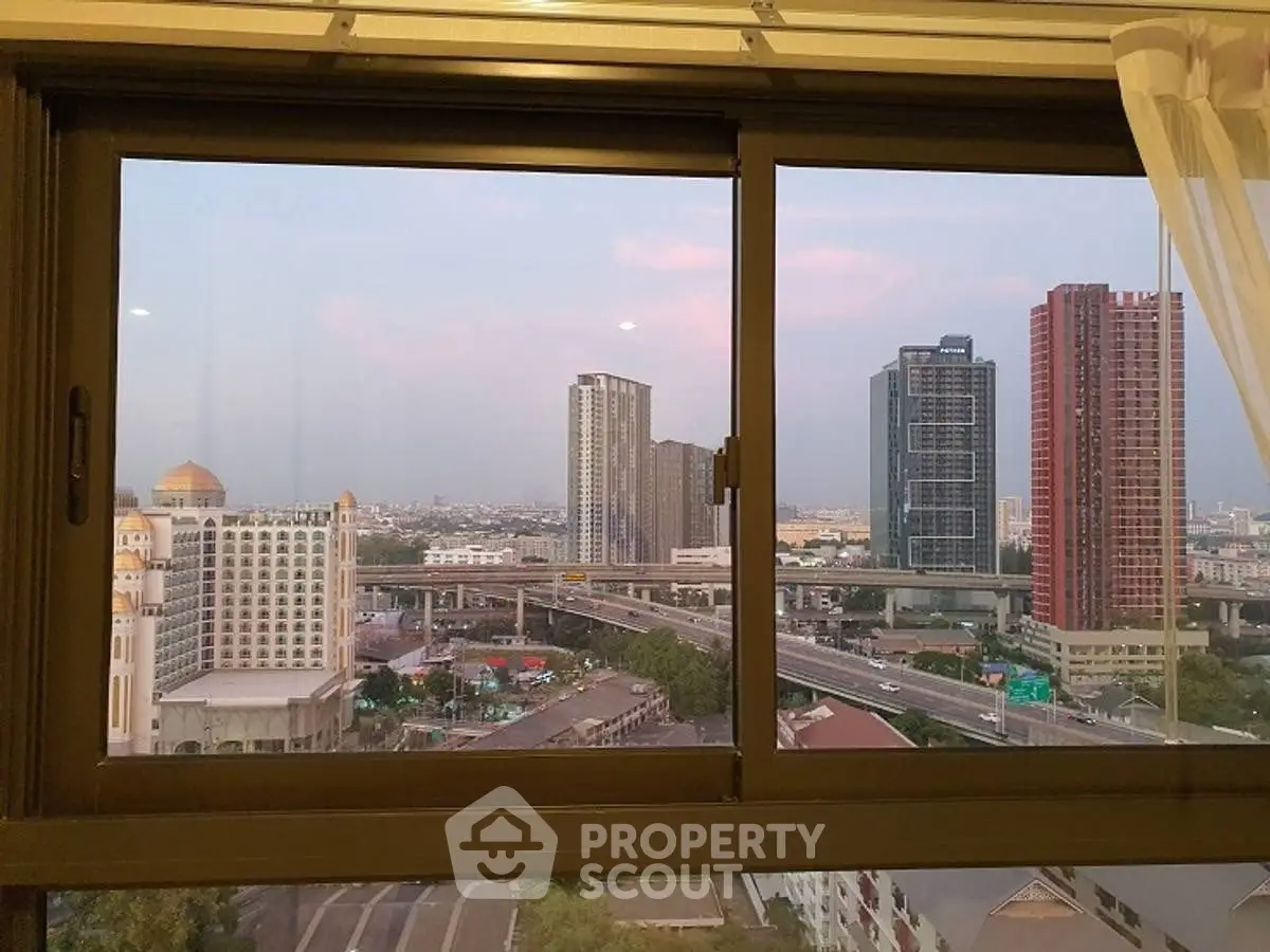 Stunning cityscape view from high-rise apartment window at sunset.
