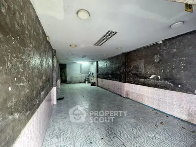 Spacious interior with tiled flooring and rustic walls, ideal for renovation or creative projects.