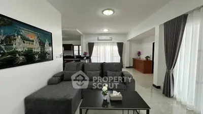 Spacious living room with modern gray sofa and elegant decor in a bright, airy apartment.