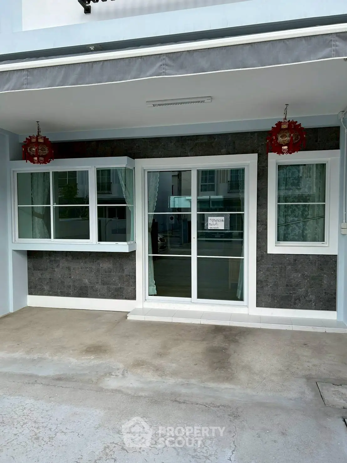 Charming residential entrance with modern glass doors and decorative lanterns, perfect for welcoming guests.