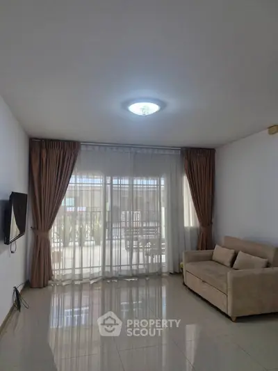 Spacious living room with elegant curtains and modern sofa, perfect for relaxation.