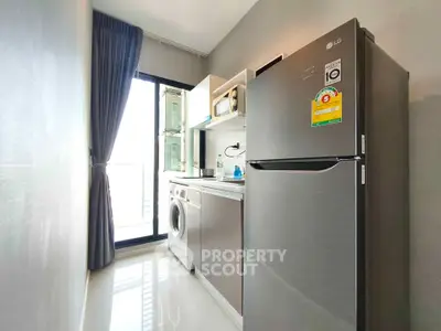 Modern kitchen with sleek appliances and natural light in a stylish apartment.