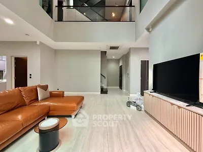 Spacious modern living room with high ceiling and elegant leather sofa
