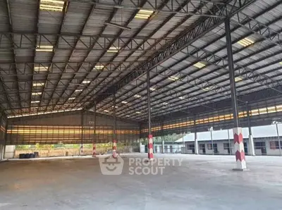 Spacious industrial warehouse with high ceilings and ample natural light.