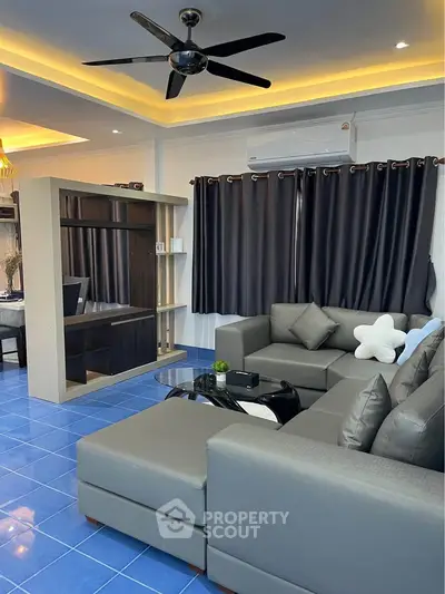 Modern living room with stylish gray sofa and blue tile flooring