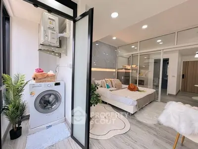 Modern studio apartment with washer and cozy bedroom, featuring stylish decor and ample natural light.