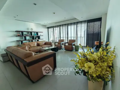 Spacious living room with modern leather sofas and large windows