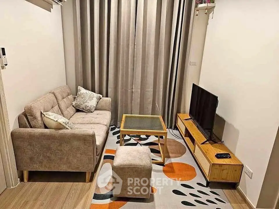 Cozy living room with modern decor, featuring a plush sofa, stylish rug, and sleek TV setup.
