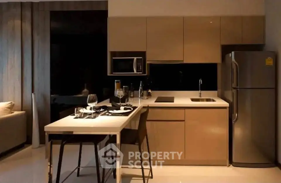 Modern kitchen with sleek cabinetry and stainless steel appliances in a stylish apartment.