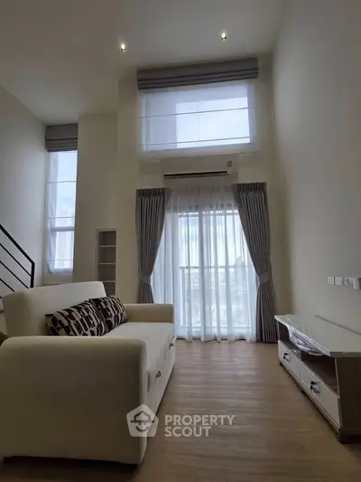 Spacious living room with high ceilings and large windows in modern apartment